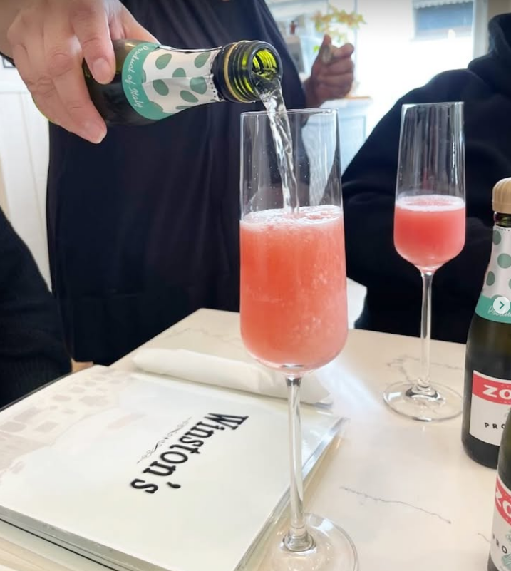 Watermelon mimosas poured over a marble Winston's menu